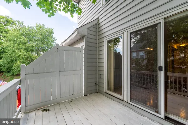 a view of small space in front of a house with wooden fence