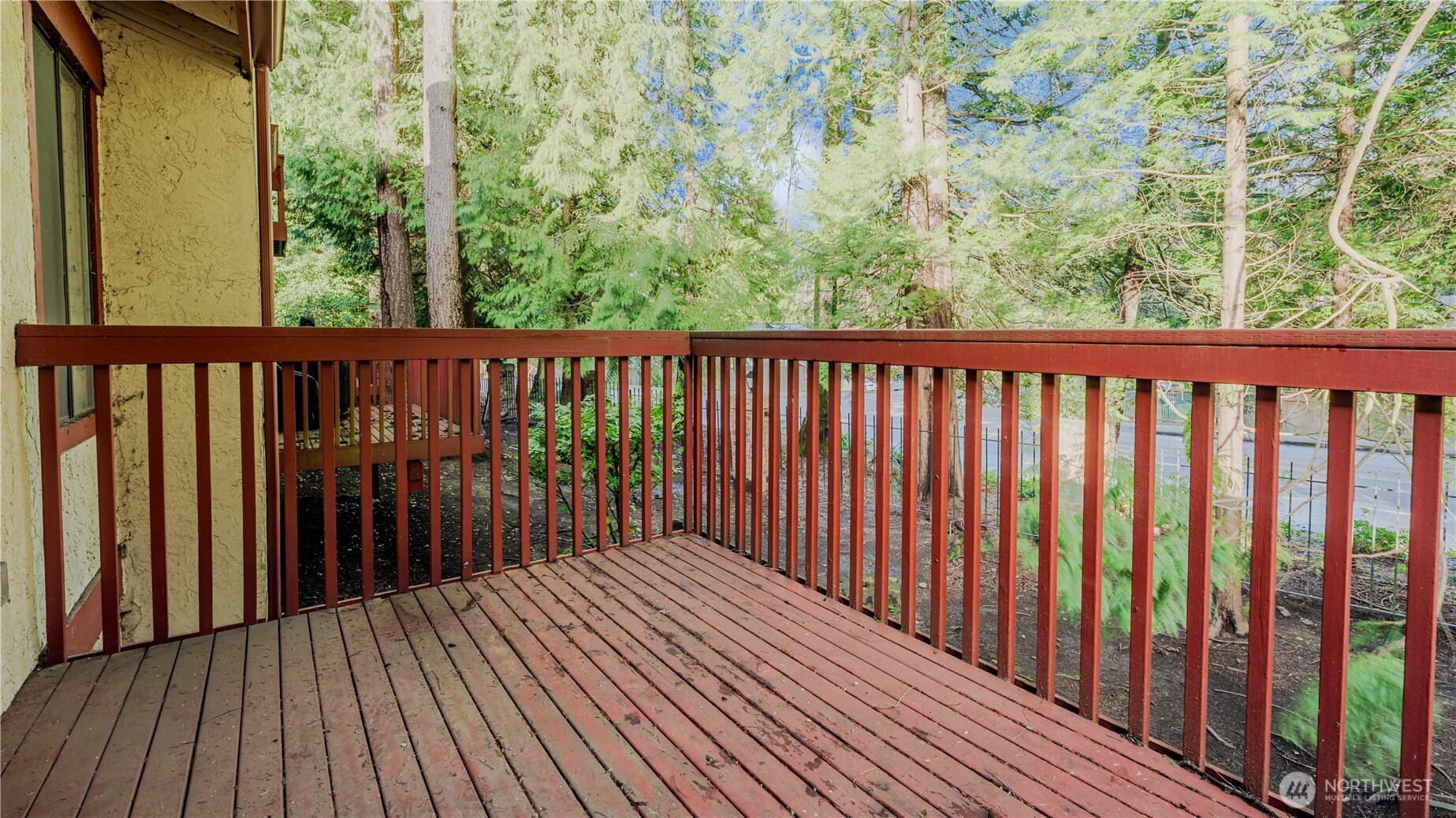 31732 47th Lane Southwest, Unit C Federal Way, WA 98023 - Photo 18 of 27 a balcony with wooden floor and trees in the back