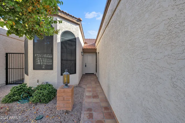 a view of a house with brick wall and plants