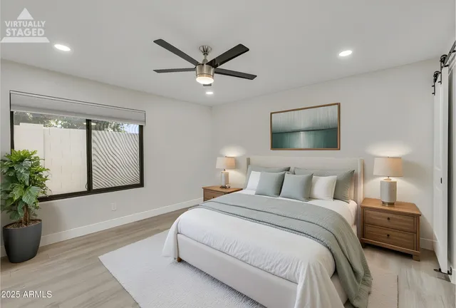 a bedroom with a large bed and a chandelier