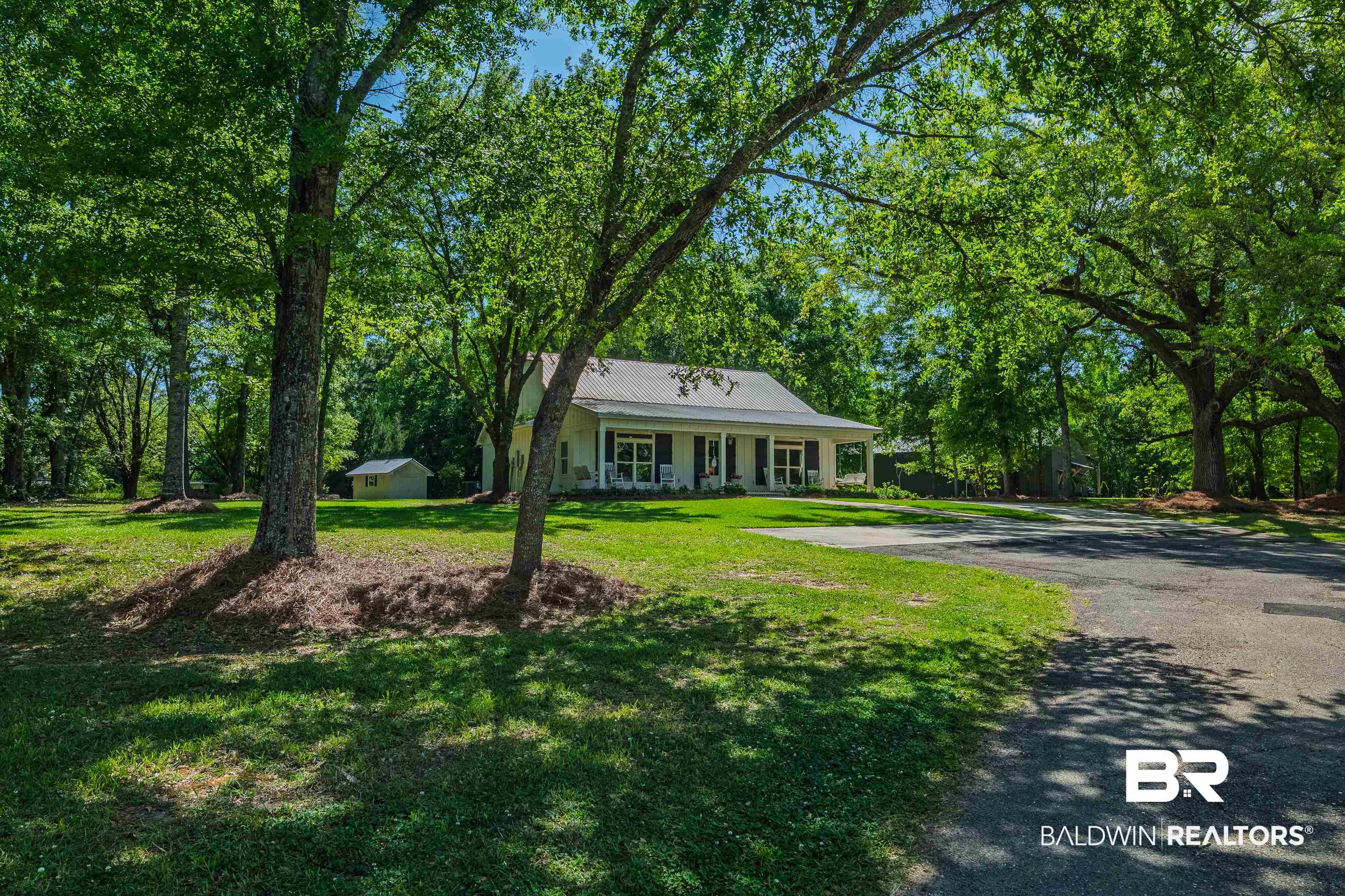 19121 Boothe Road Fairhope, AL 36532 - Photo 3 of 41 View of front of home with a porch, driveway, view of scattered trees, and a front lawn