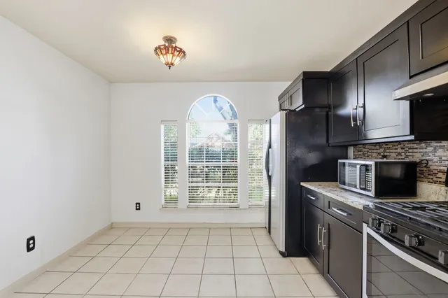 a kitchen with a stove a refrigerator and a stove top oven