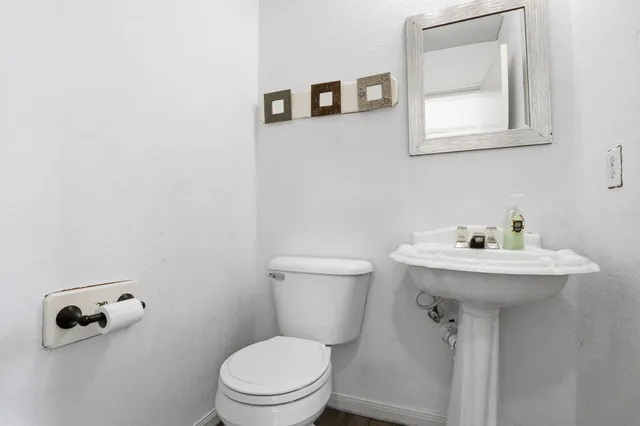 a bathroom with a sink mirror and toilet