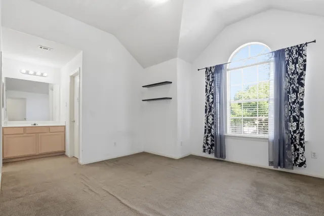 a view of an empty room with window and cabinet