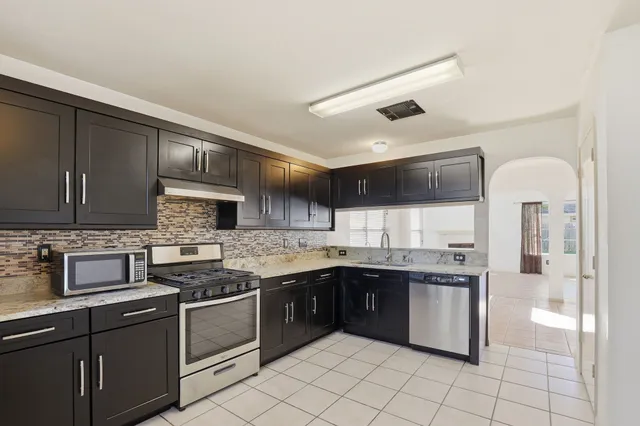 a kitchen with stainless steel appliances granite countertop a sink and cabinets