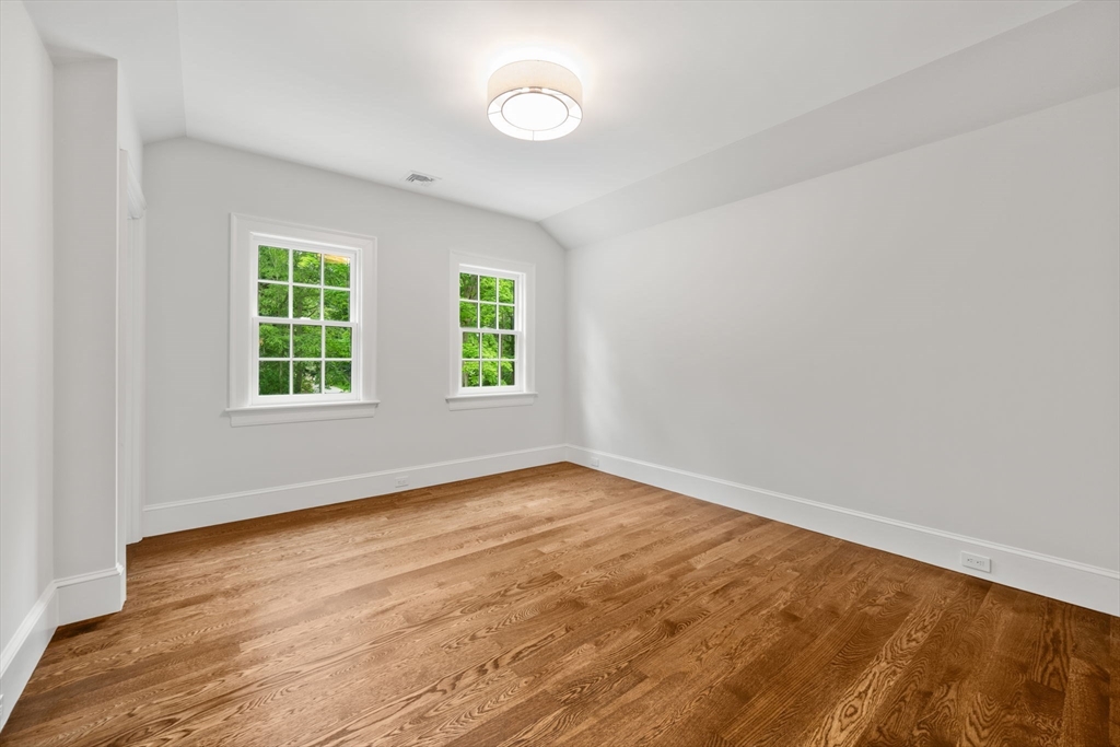 61 Heath Street Brookline, MA 02467 - Photo 32 of 40 an empty room with wooden floor and windows