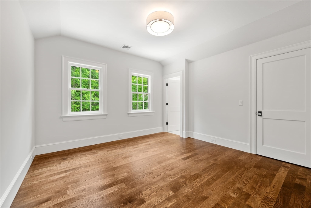 61 Heath Street Brookline, MA 02467 - Photo 36 of 40 a view of an empty room with a window and wooden floor