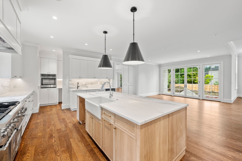 61 Heath Street Brookline, MA 02467 - Photo 6 of 40 a large kitchen with kitchen island a stove a sink a center island and windows