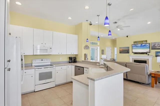 a kitchen that has a lot of white cabinets and stainless steel appliances