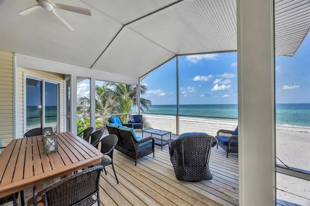 a view of chairs and table on the wooden deck