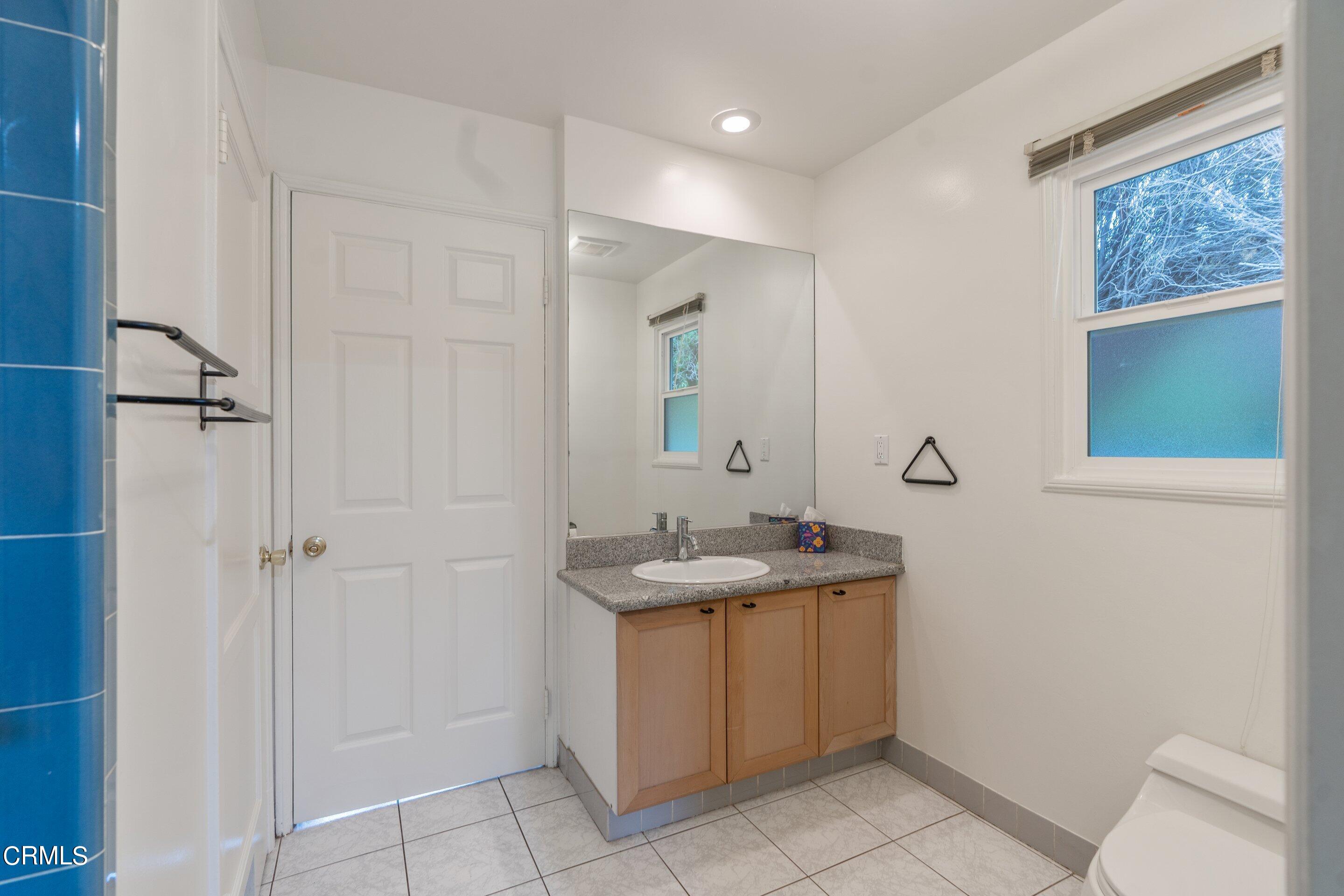 3815 Mayfair Drive Pasadena, CA 91107 - Photo 17 of 38 a bathroom with a granite countertop sink a mirror and a shower