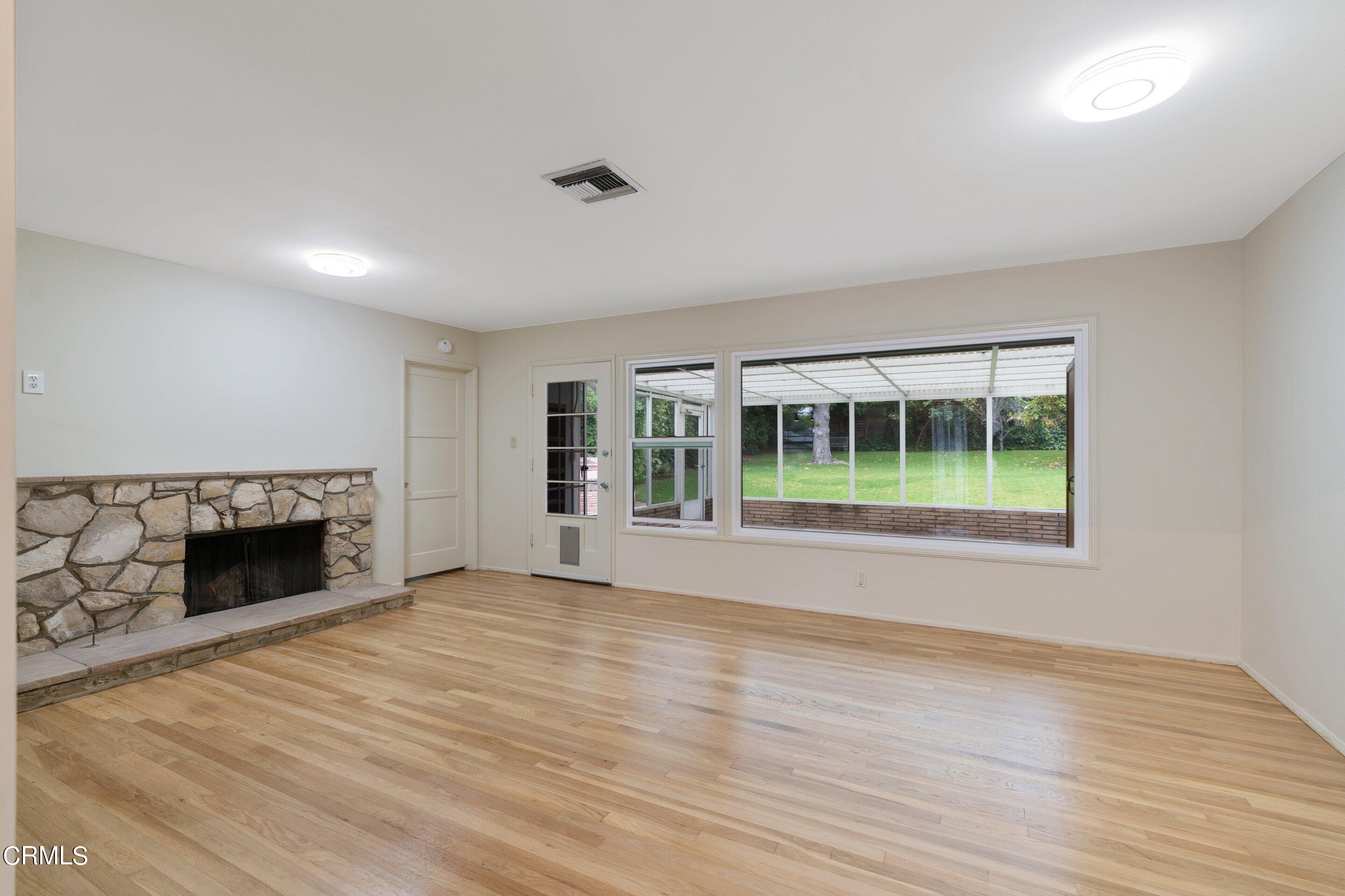 3815 Mayfair Drive Pasadena, CA 91107 - Photo 7 of 38 a view of an empty room with wooden floor fireplace and a window