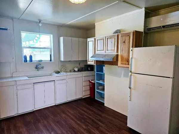 a kitchen with a refrigerator stove and wooden cabinets