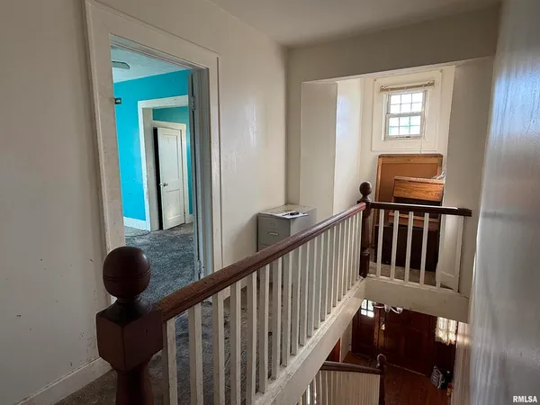 an empty room that has a window and kitchen view