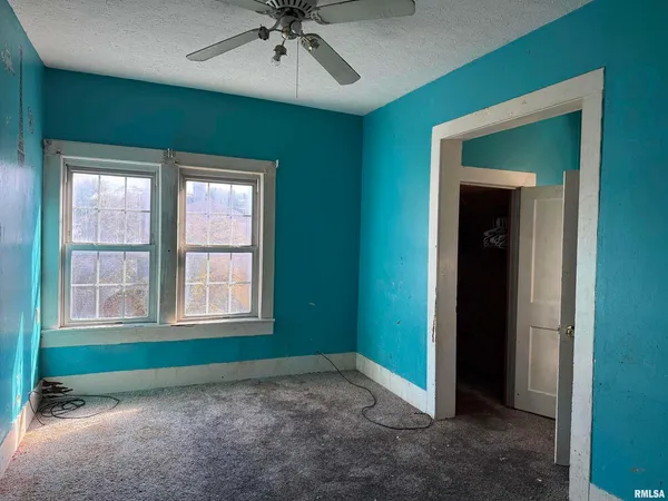 an empty room with closet and entryway
