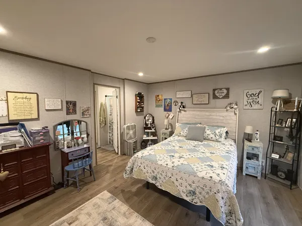 a bedroom with a bed and wooden floor