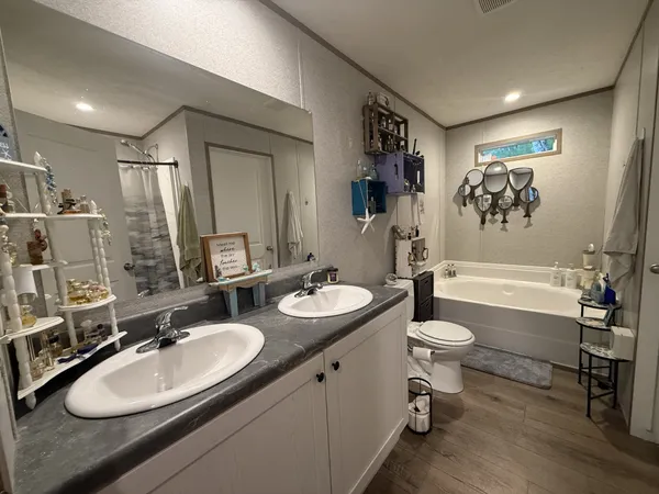 a bathroom with a granite countertop sink toilet a mirror and bathtub