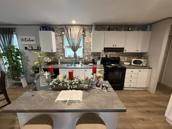 a kitchen with stainless steel appliances granite countertop a refrigerator sink stove and cabinets