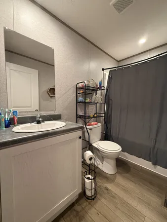 a bathroom with a toilet a sink and shower