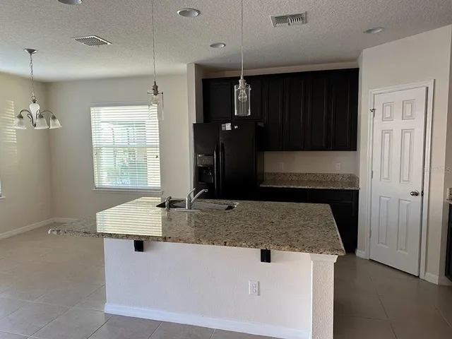 a kitchen with granite countertop a sink stainless steel appliances and cabinets