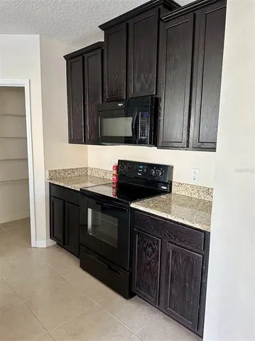 a kitchen with granite countertop stainless steel appliances wooden cabinets and a sink