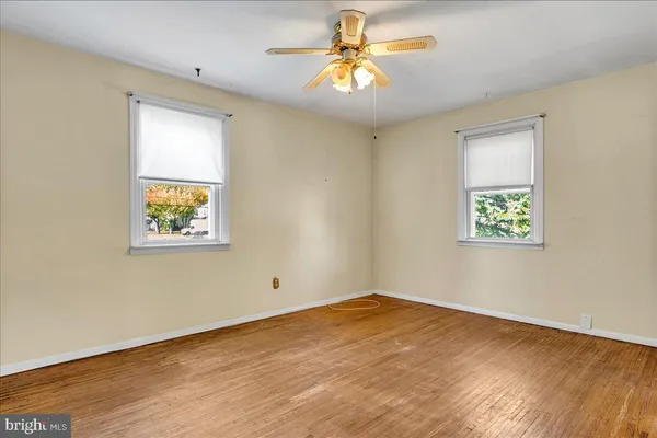 an empty room with a window and a ceiling fan