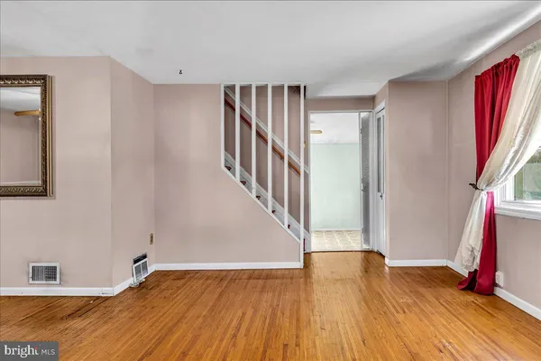a view of front door with hallway and wooden floor