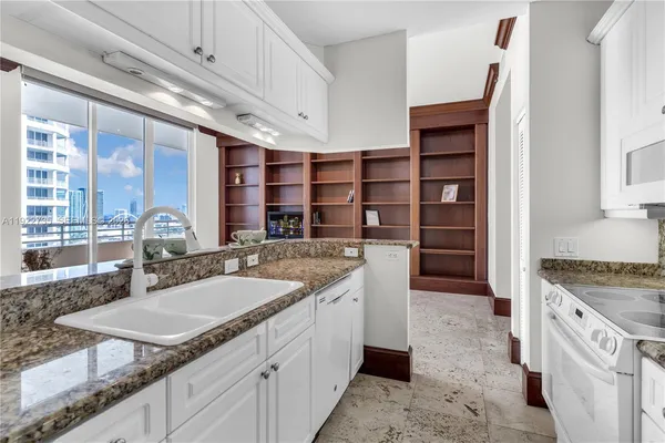 a kitchen with kitchen island granite countertop a sink and a stove
