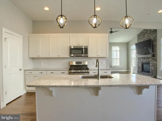 a kitchen with stainless steel appliances granite countertop a sink a stove and a microwave