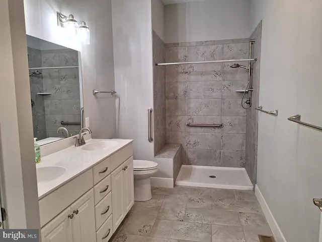 a bathroom with a granite countertop sink toilet and shower