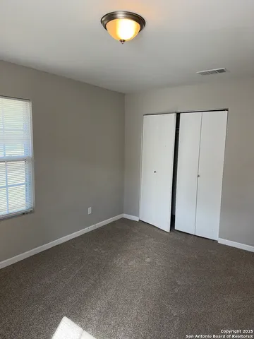 an empty room with a window and a ceiling fan