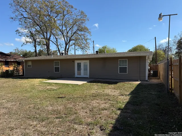 a front view of house with yard and trees in the background