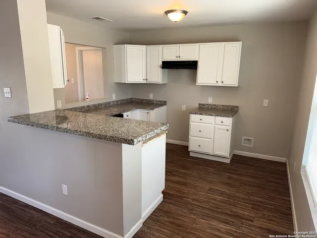 a kitchen with stainless steel appliances granite countertop a sink stove and cabinets