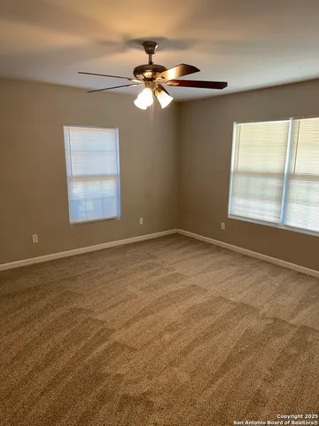 a view of a livingroom with a ceiling fan and window