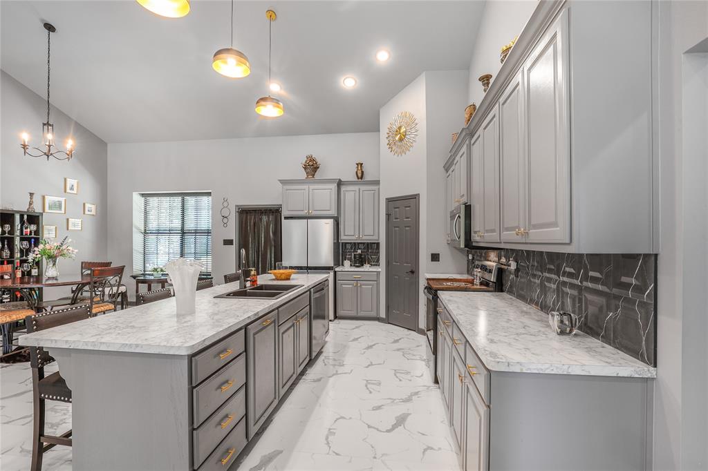 1373 George Ephram Cord 166 Road Overton, TX 75684 - Photo 13 of 40 Vaulted ceiling, recessed lighting, central island with an undermount sink, grey cabinetry, and white countertops