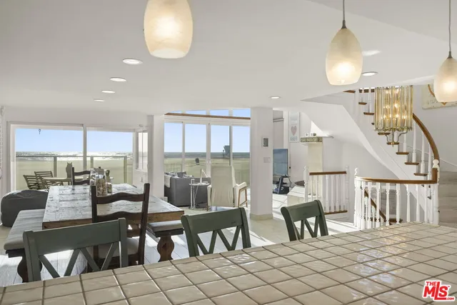 a kitchen with kitchen island a dining table and chairs