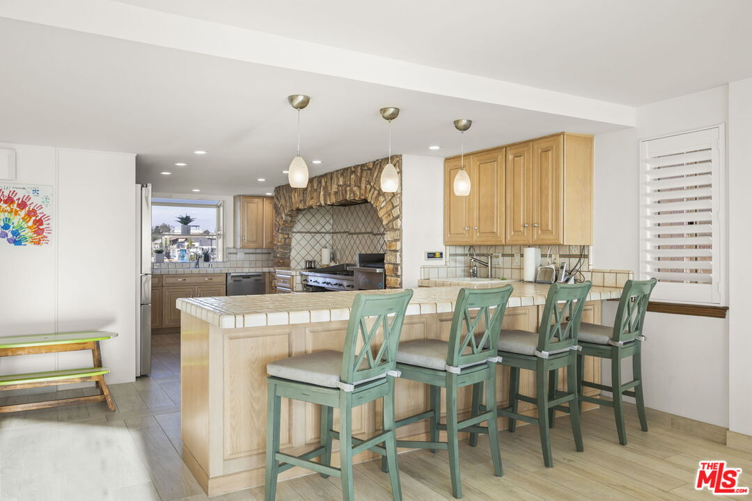 1005 Ocean Drive Oxnard, CA 93035 - Photo 29 of 56 a kitchen with kitchen island a dining table and chairs