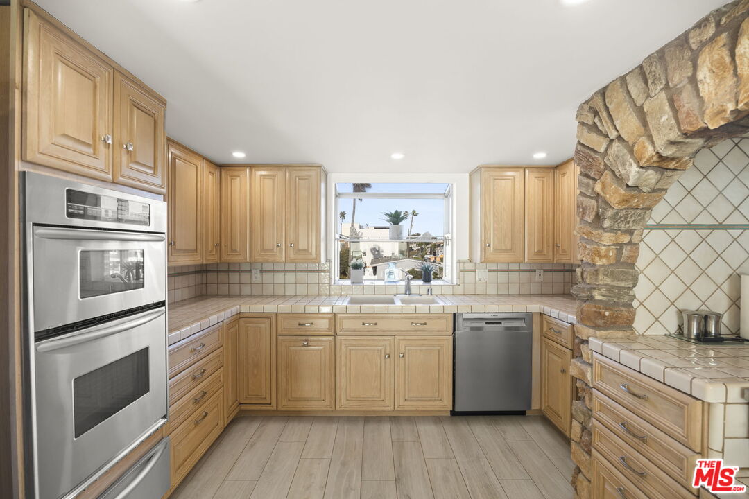 1005 Ocean Drive Oxnard, CA 93035 - Photo 32 of 56 a kitchen with stainless steel appliances granite countertop a stove a sink and a refrigerator