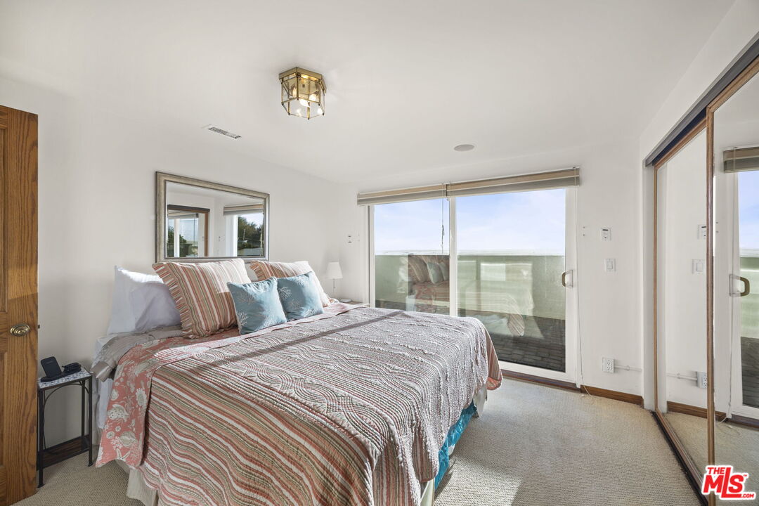 1005 Ocean Drive Oxnard, CA 93035 - Photo 38 of 56 a bedroom with a balcony a bed and a chandelier