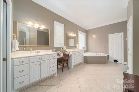 a large bathroom with a large tub sink and vanity
