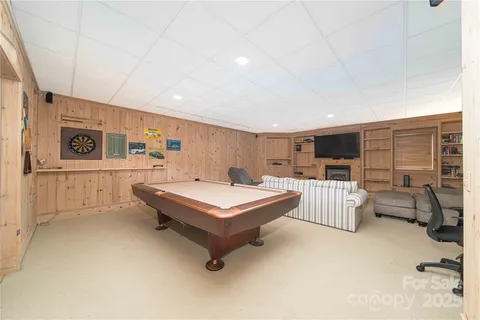 a living room with furniture pool table and flat screen tv