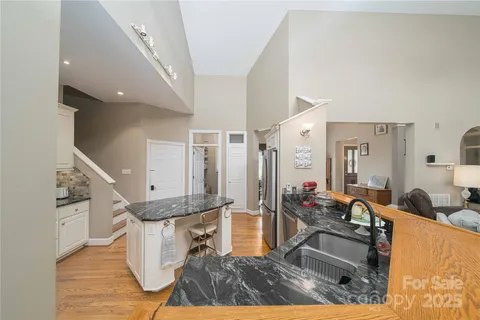 a living room with table chairs and a large window