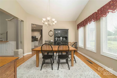 a view of a dining room with furniture wooden floor and chandelier