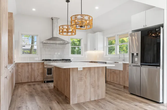 a kitchen with stainless steel appliances granite countertop a stove and a wooden floors