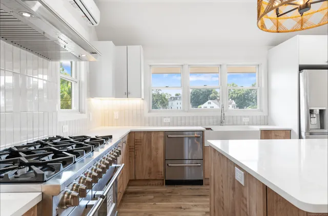 a kitchen with stainless steel appliances a sink a stove and a wooden floors