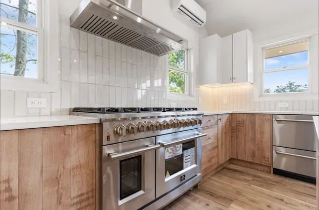 a kitchen with a stove and a white wooden cabinets