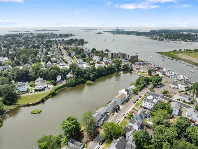an aerial view of ocean and residential houses with outdoor space