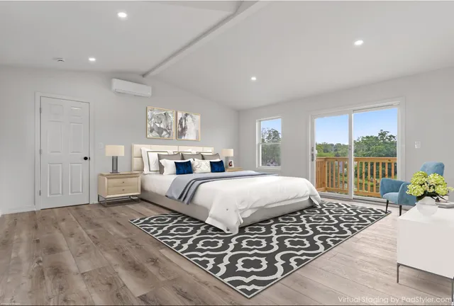 a spacious bedroom with a bed a couch and a large window