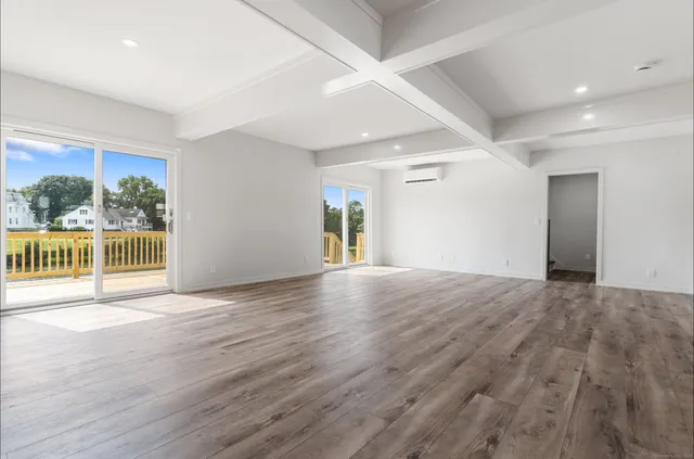 a view of a big room with wooden floor and a window