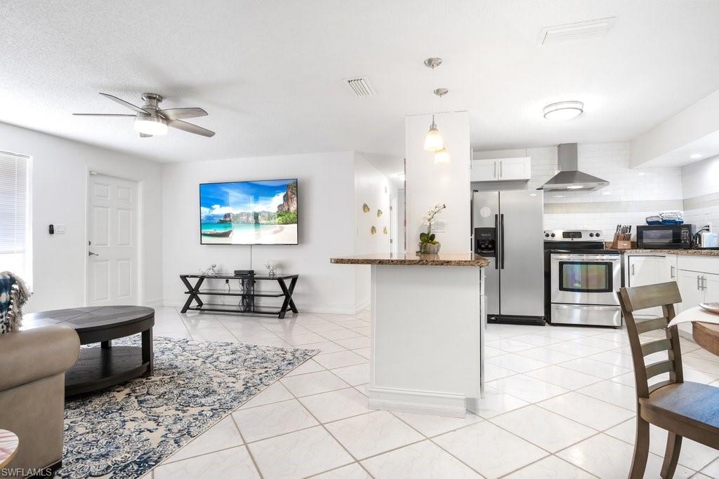 1207 Hernando Street Naples, FL 34103 - Photo 6 of 37 a kitchen with stainless steel appliances kitchen island granite countertop a refrigerator and cabinets